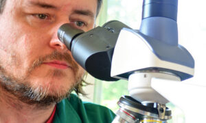 Stephen Klusza with a microscope